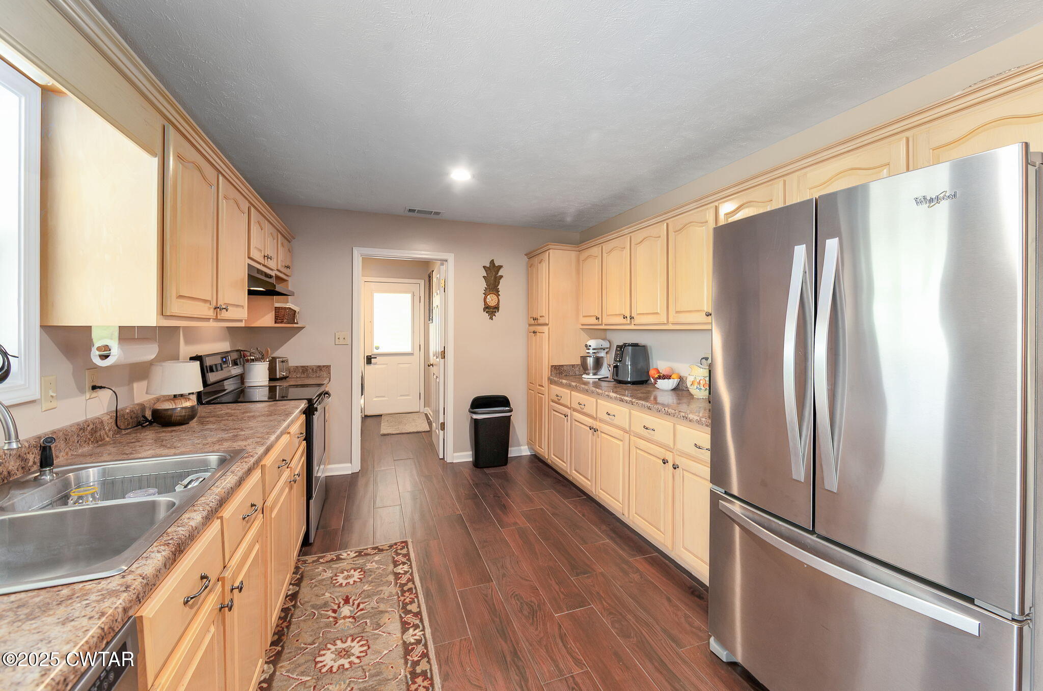 114 Falcon Cove Middleton, TN 38052 - Photo 6 of 24 a kitchen with stainless steel appliances granite countertop a refrigerator a sink dishwasher a stove and white countertops with wooden floor