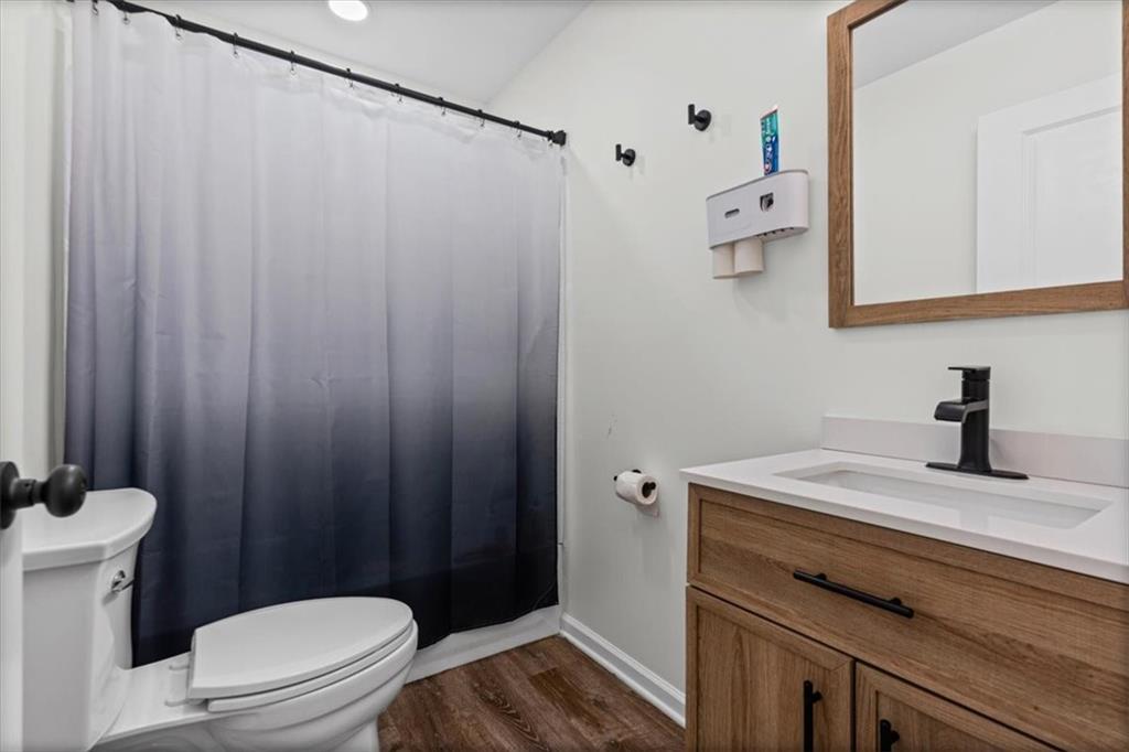 62 Dude Street Northwest Rome, GA 30165 - Photo 17 of 21 a bathroom with a sink a toilet and shower curtain