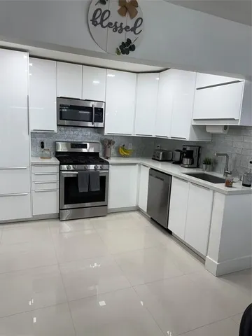 a metallic refrigerator freezer sitting in a kitchen