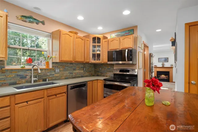 a kitchen with kitchen island granite countertop a sink counter top space appliances and cabinets