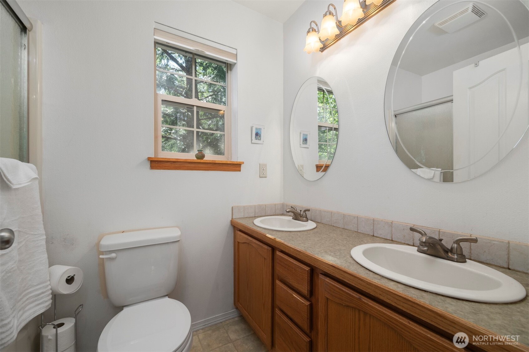 337 Sudden Valley Drive Bellingham, WA 98229 - Photo 26 of 40 a bathroom with a toilet a sink a mirror and a window