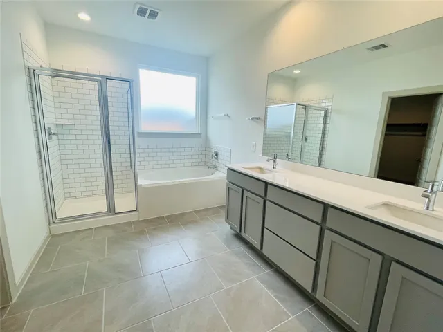 a spacious bathroom with a mirror sink and bathtub