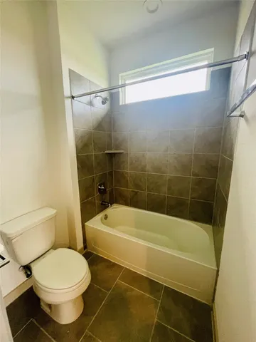 a bathroom with a toilet and a bath tub