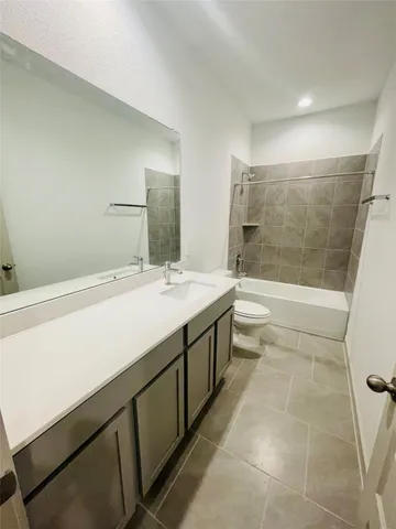 a bath room with a sink a toilet and shower