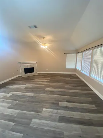 a view of a room with wooden floor and window