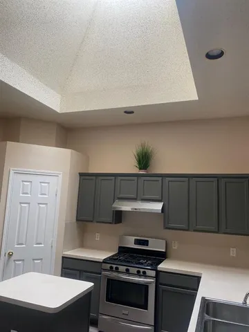 a kitchen with sink a stove and cabinets