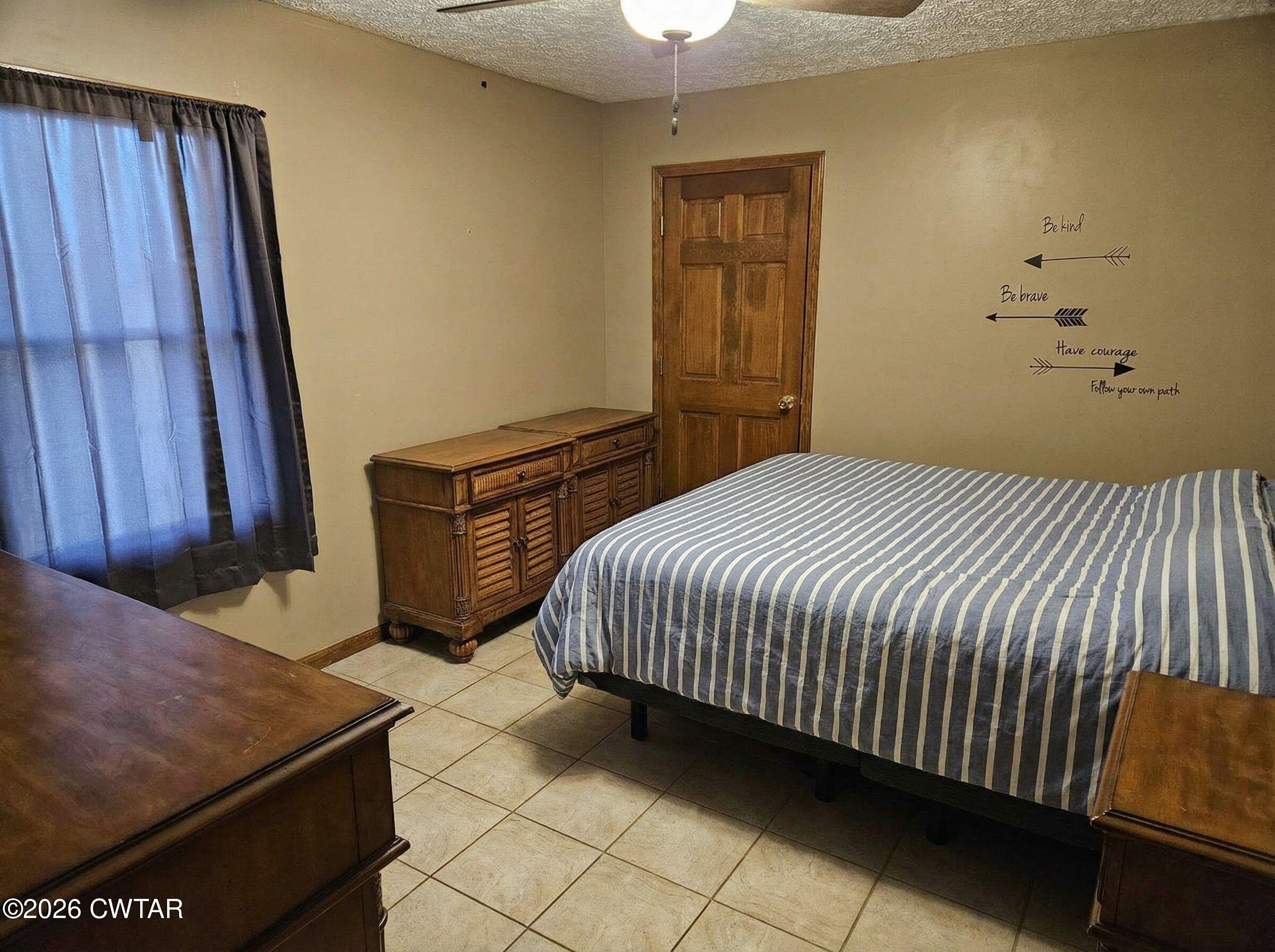 103 Spring Creek Law Road Jackson, TN 38305 - Photo 14 of 35 a bedroom with a bed and wooden floor