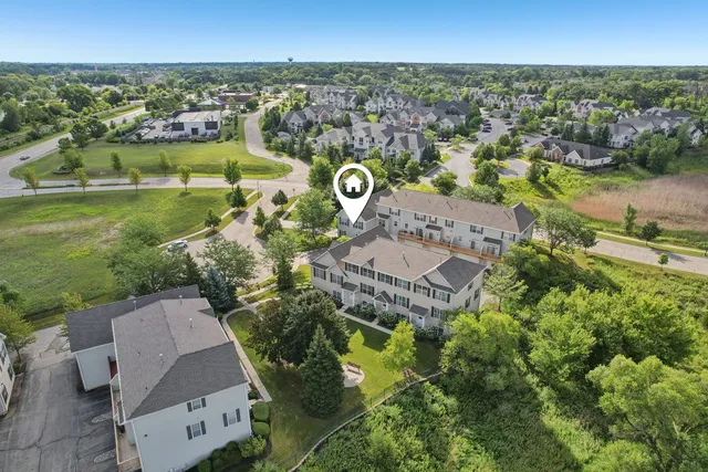 an aerial view of a house with a garden and lake view