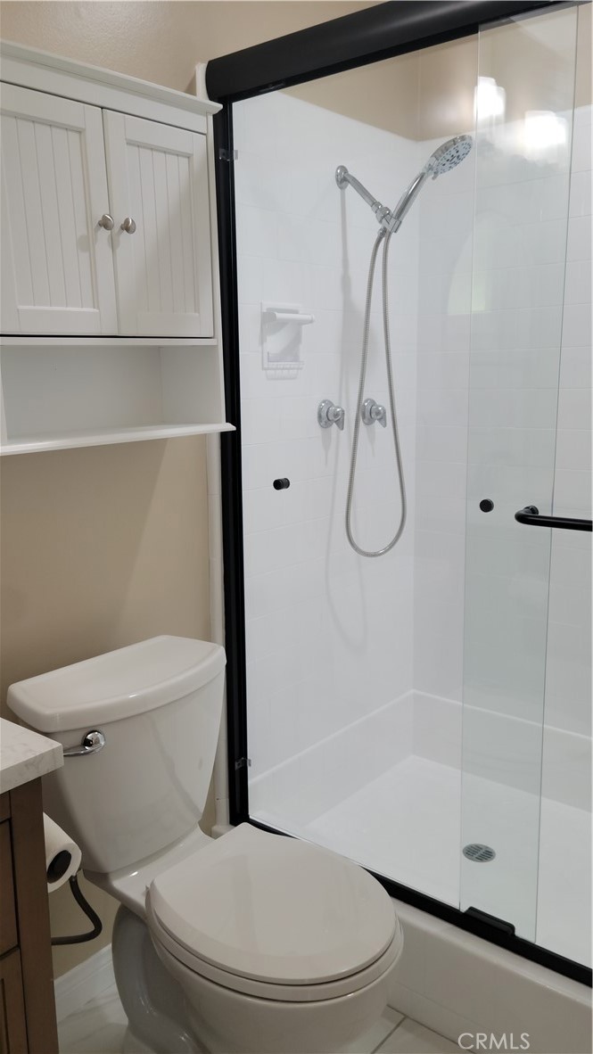 1309 Stillman Avenue Redlands, CA 92374 - Photo 12 of 23 a bathroom with a toilet and a glass shower door