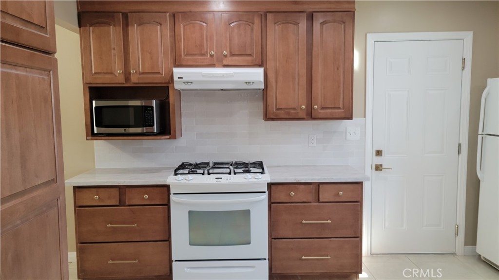 1309 Stillman Avenue Redlands, CA 92374 - Photo 5 of 23 a kitchen with granite countertop cabinets and a stove top oven