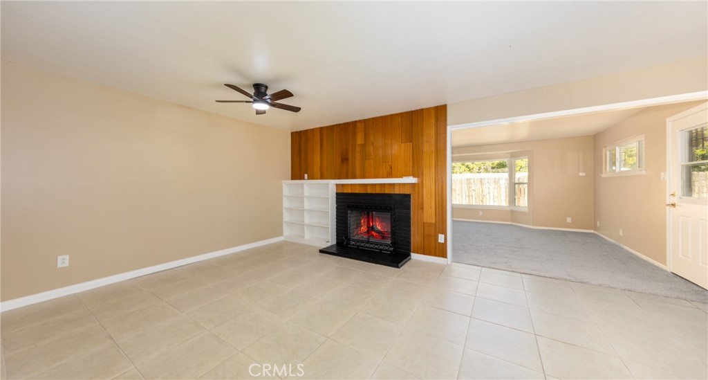 1309 Stillman Avenue Redlands, CA 92374 - Photo 7 of 23 an empty room with windows fireplace and a ceiling fan