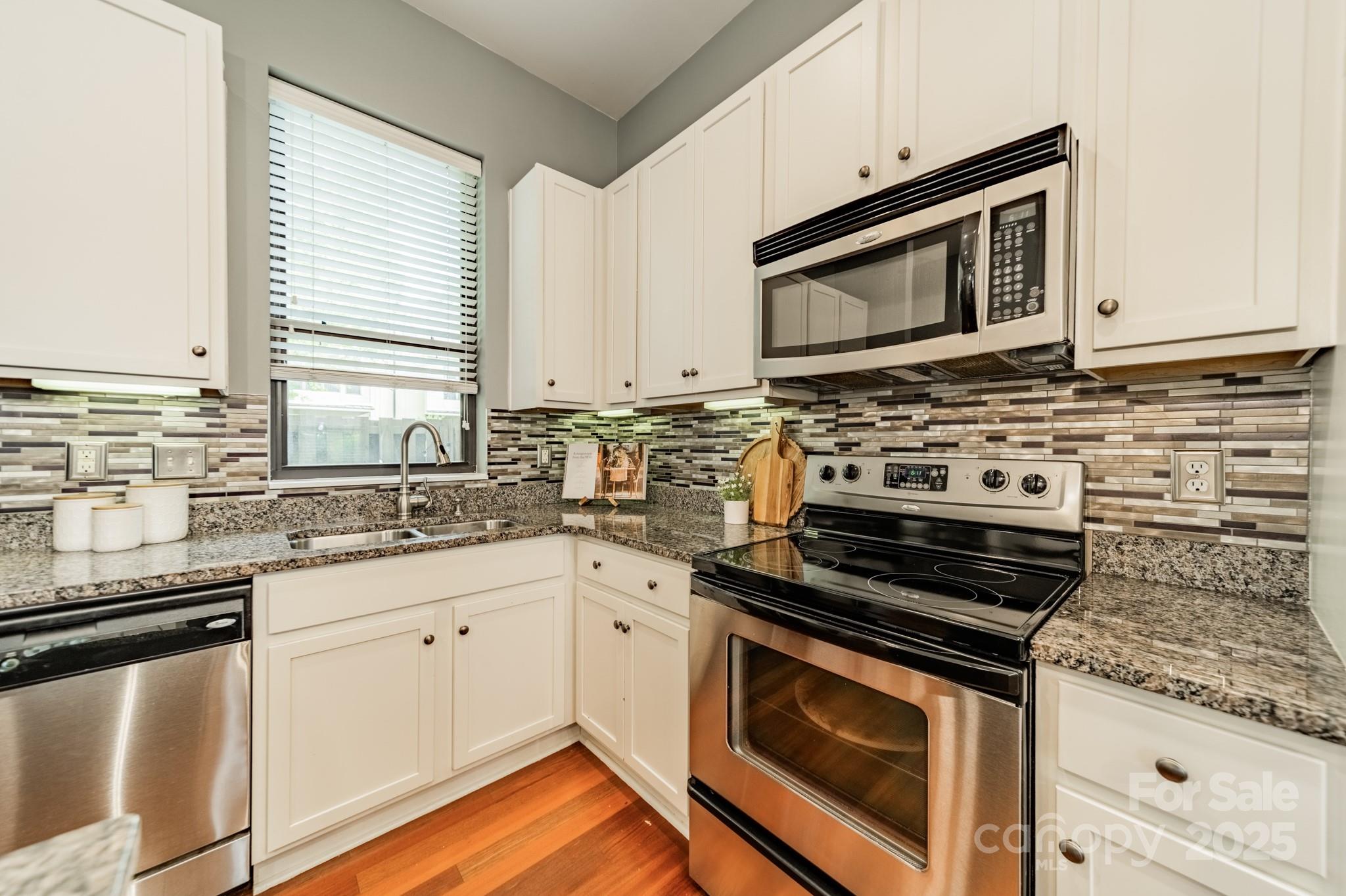 2988 Textile Way Charlotte, NC 28205 - Photo 5 of 36 a kitchen with stainless steel appliances a stove microwave and sink