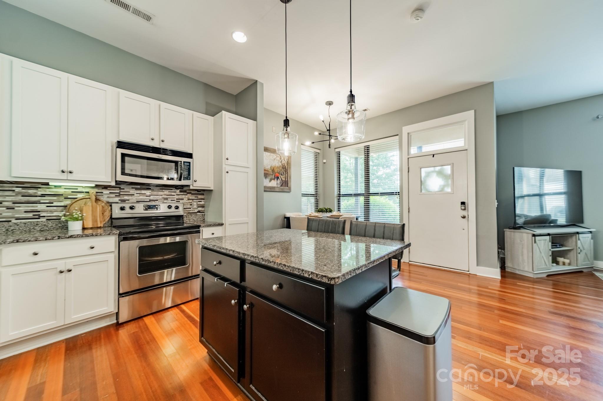 2988 Textile Way Charlotte, NC 28205 - Photo 7 of 36 a kitchen with granite countertop a stove top oven a sink dishwasher a dining table and chairs with wooden floor