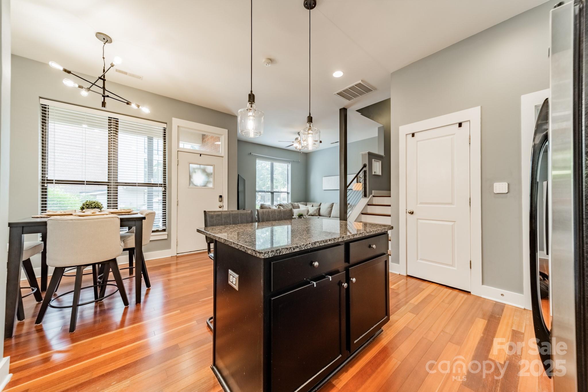 2988 Textile Way Charlotte, NC 28205 - Photo 9 of 36 a kitchen with stainless steel appliances granite countertop a refrigerator a sink dishwasher a dining table and chairs with wooden floor