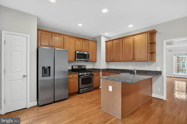 a kitchen with granite countertop stainless steel appliances and wooden cabinets