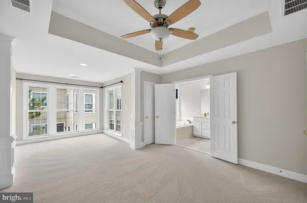 a view of an empty room with a window and a kitchen view