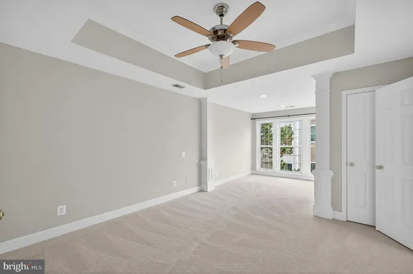 an empty room with fan and windows