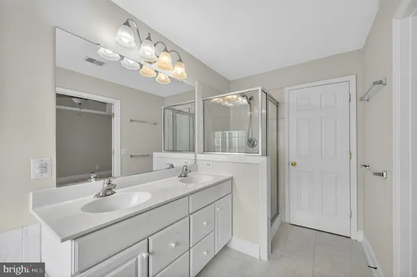 a bathroom with a sink a light fixture and a mirror