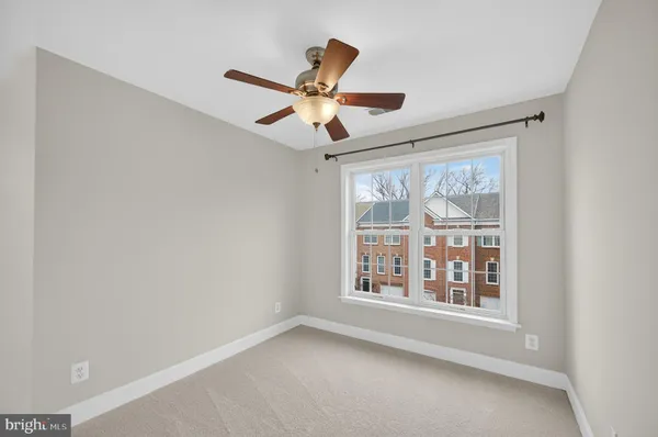 an empty room with ceiling fan and window