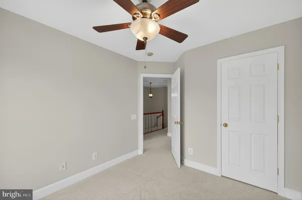 an empty room with closet and a ceiling fan