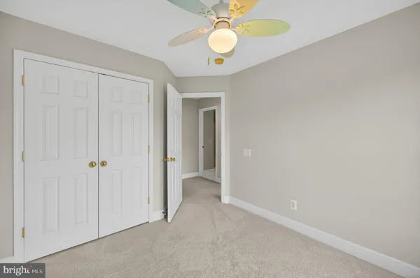 a view of an empty room with a chandelier fan
