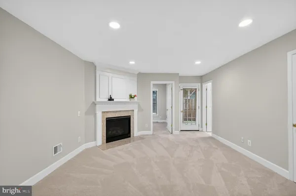 a view of an empty room with a fireplace and a window