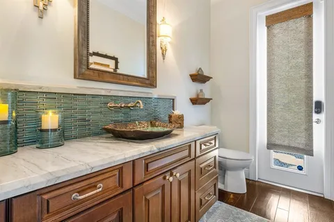 a view of a patio with couches table and chairs under an umbrella