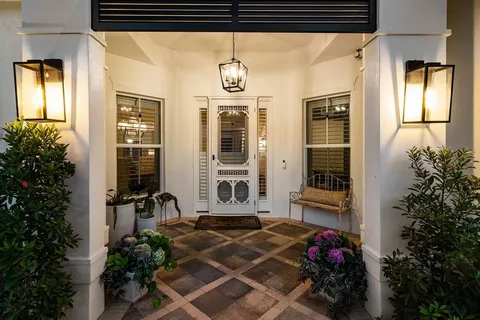 a view of a porch with couches potted plants and wooden fence
