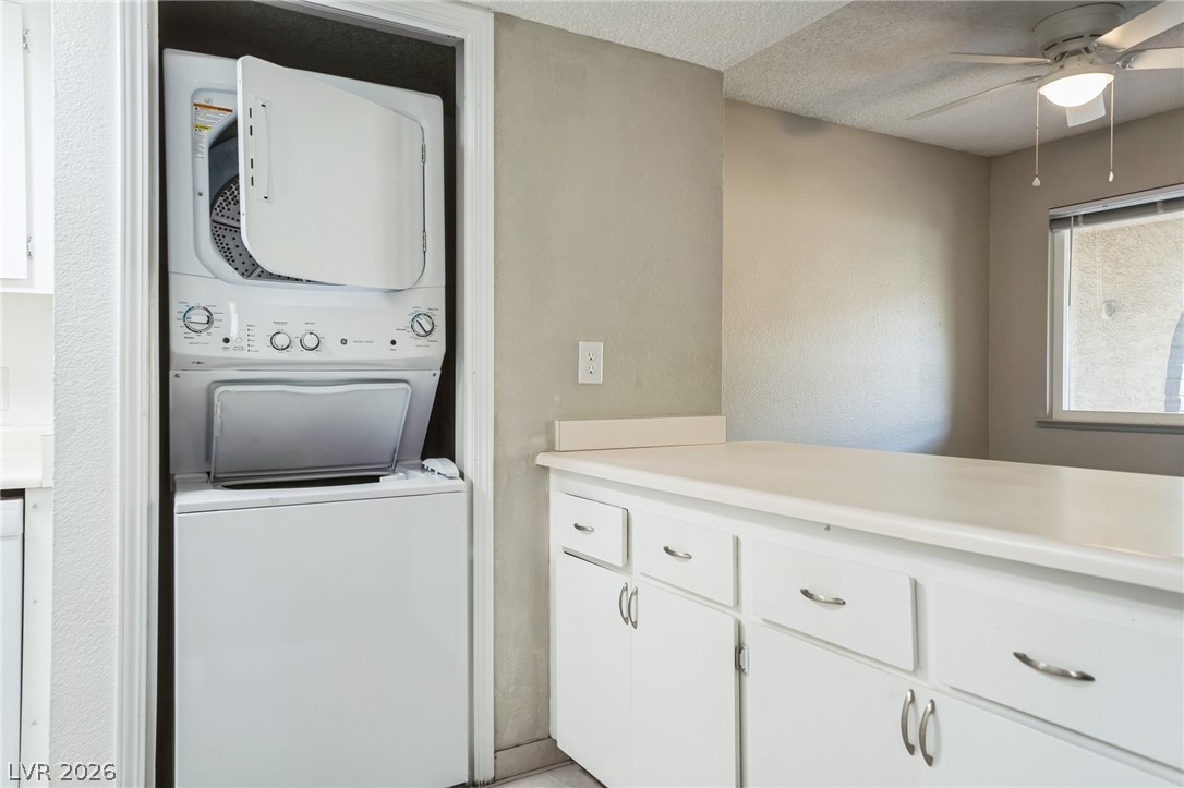 5733 Smoke Ranch Road, Unit D Las Vegas, NV 89108 - Photo 11 of 14 Laundry area with ceiling fan, stacked washer and dryer, and a textured ceiling