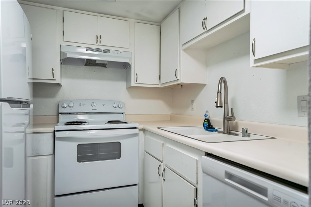 5733 Smoke Ranch Road, Unit D Las Vegas, NV 89108 - Photo 6 of 14 Kitchen featuring white appliances, white cabinetry, and light countertops