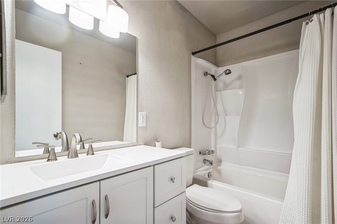 5733 Smoke Ranch Road, Unit D Las Vegas, NV 89108 - Photo 9 of 14 Full bathroom with vanity, a textured wall, and shower / tub combo
