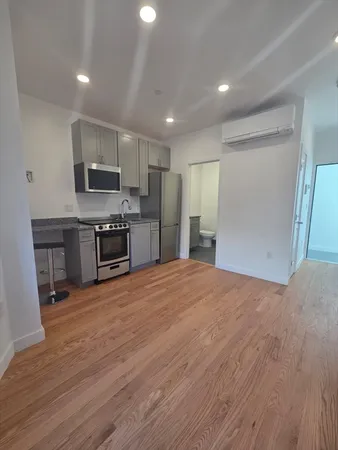 a large kitchen with a stove a refrigerator and a microwave