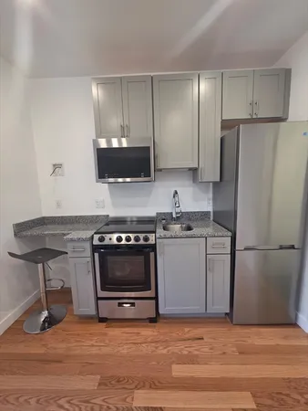 a kitchen with a refrigerator and a stove top oven