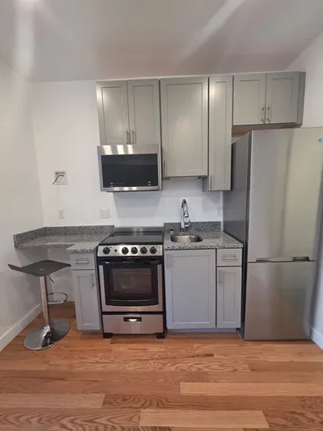 a kitchen with a refrigerator and a stove top oven