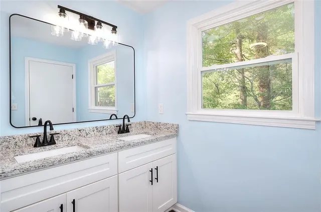 a bathroom with a granite countertop sink and a mirror