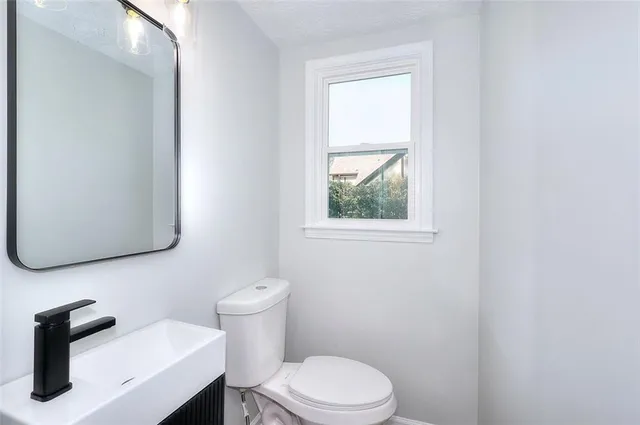 a bathroom with a toilet sink and mirror