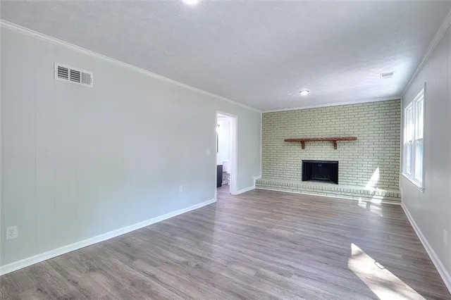 a view of empty room with wooden floor and fireplace