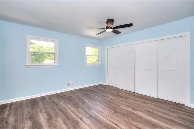 a view of empty room with window and ceiling fan