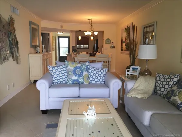 a living room with furniture and a chandelier