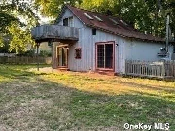 a view of a house with a yard and wooden fence