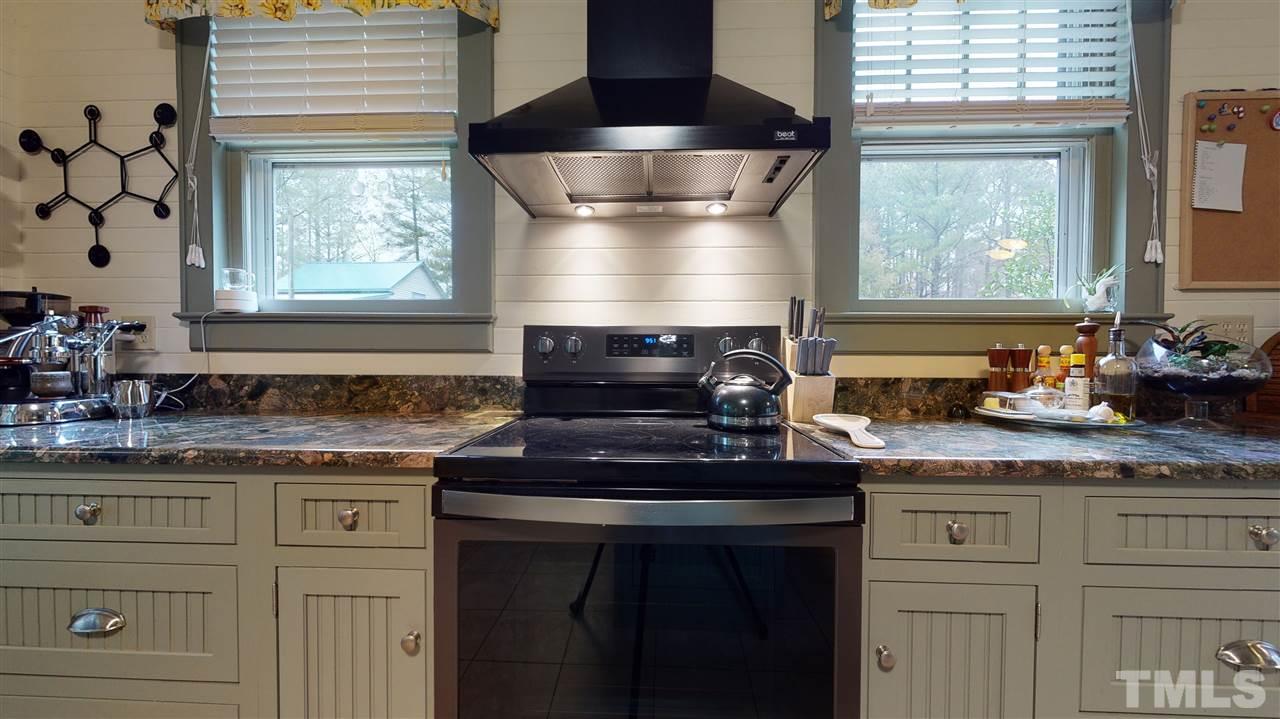 4007 Redwood Road Durham, NC 27704 - Photo 17 of 30 This cooking space has wide open views of the rear of the property. Omega cabinets, granite counter tops and updated light fixtures.