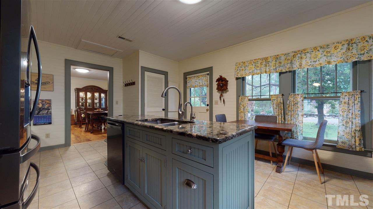 4007 Redwood Road Durham, NC 27704 - Photo 18 of 30 The island commands attention in this well thought out kitchen. Breakfast nook is the perfect spot to enjoy your morning coffee and watch the birds in the park-like side yard.