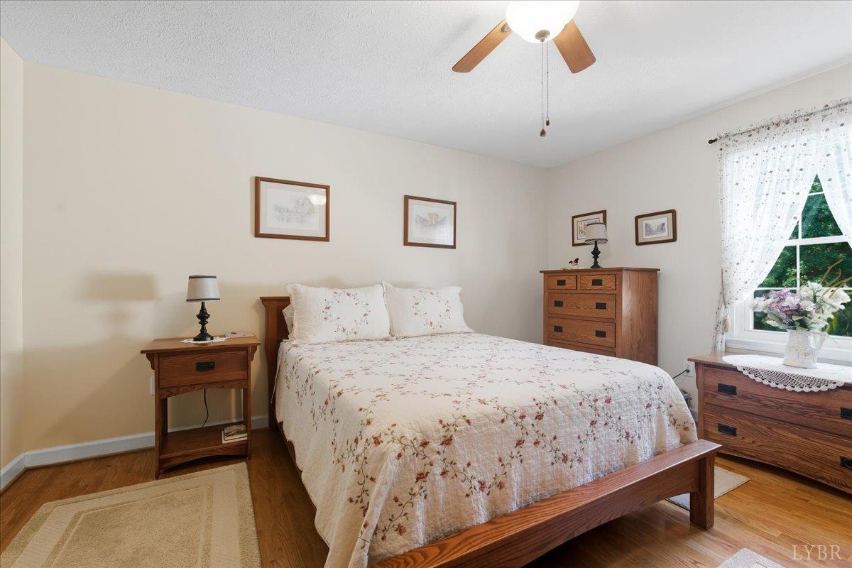 2121 Sunburst Road Evington, VA 24550 - Photo 14 of 41 a bedroom with a bed and wooden floor
