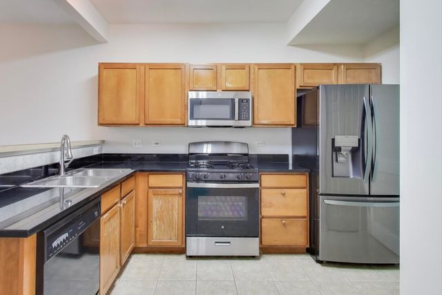 a kitchen with stainless steel appliances granite countertop a refrigerator stove and sink