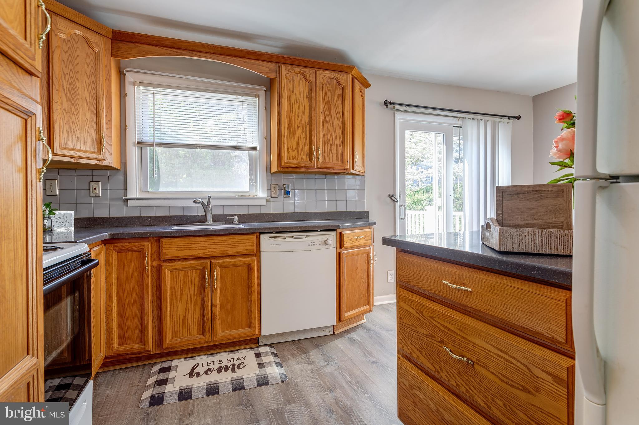 1105 Wynnbrook Road Secane, PA 19018 - Photo 11 of 30 a kitchen with granite countertop wooden cabinets a sink and a window