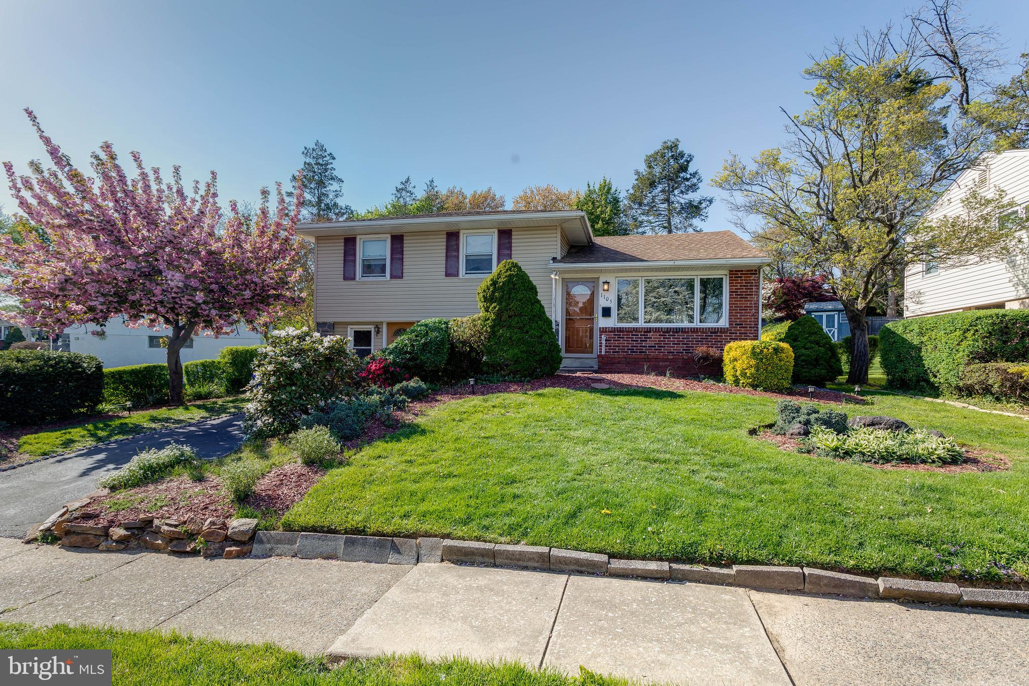1105 Wynnbrook Road Secane, PA 19018 - Photo 2 of 30 a front view of a house with a garden and trees
