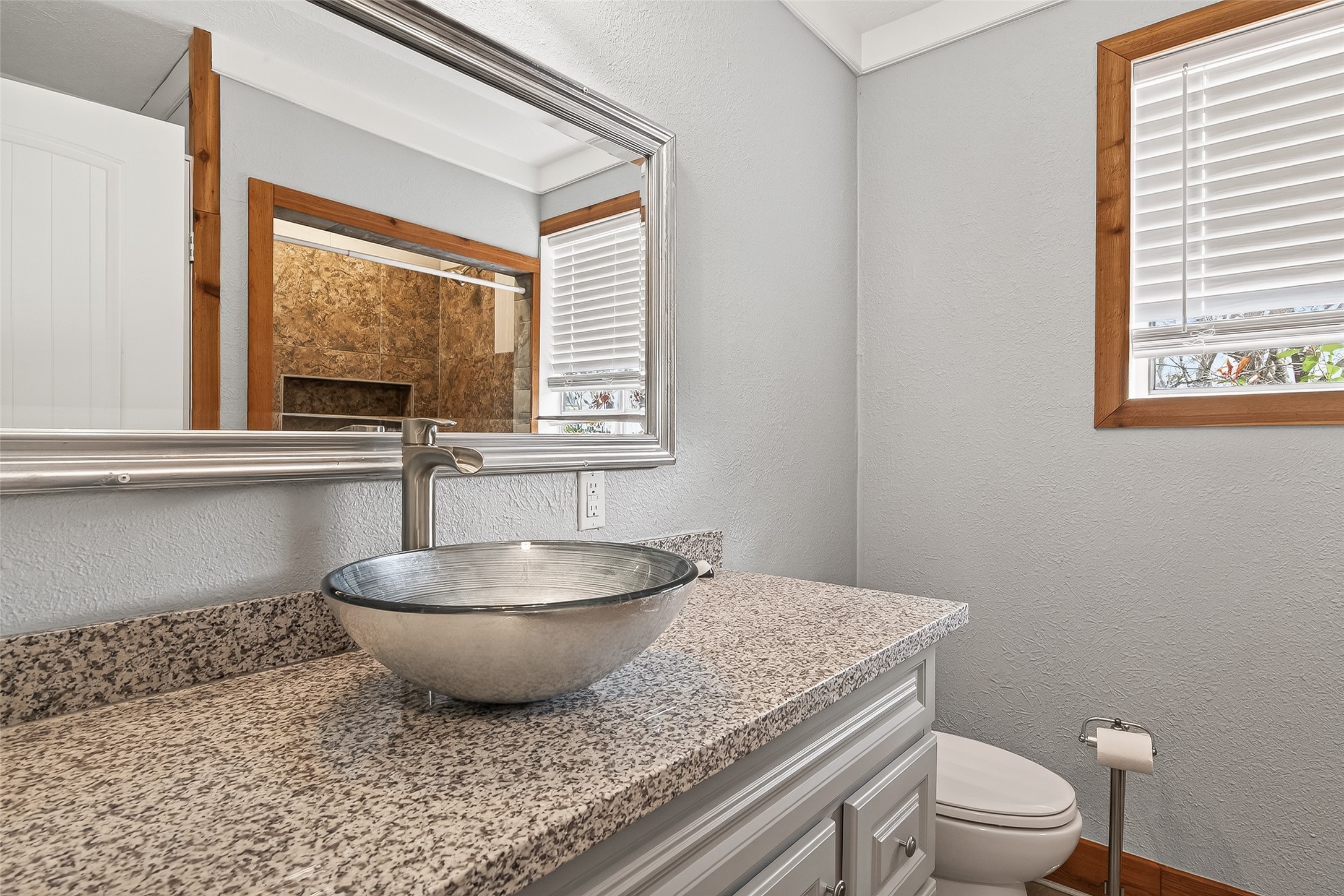 403 Wrangler Road Simonton, TX 77485 - Photo 12 of 33 a bathroom with a granite countertop toilet a sink and a window