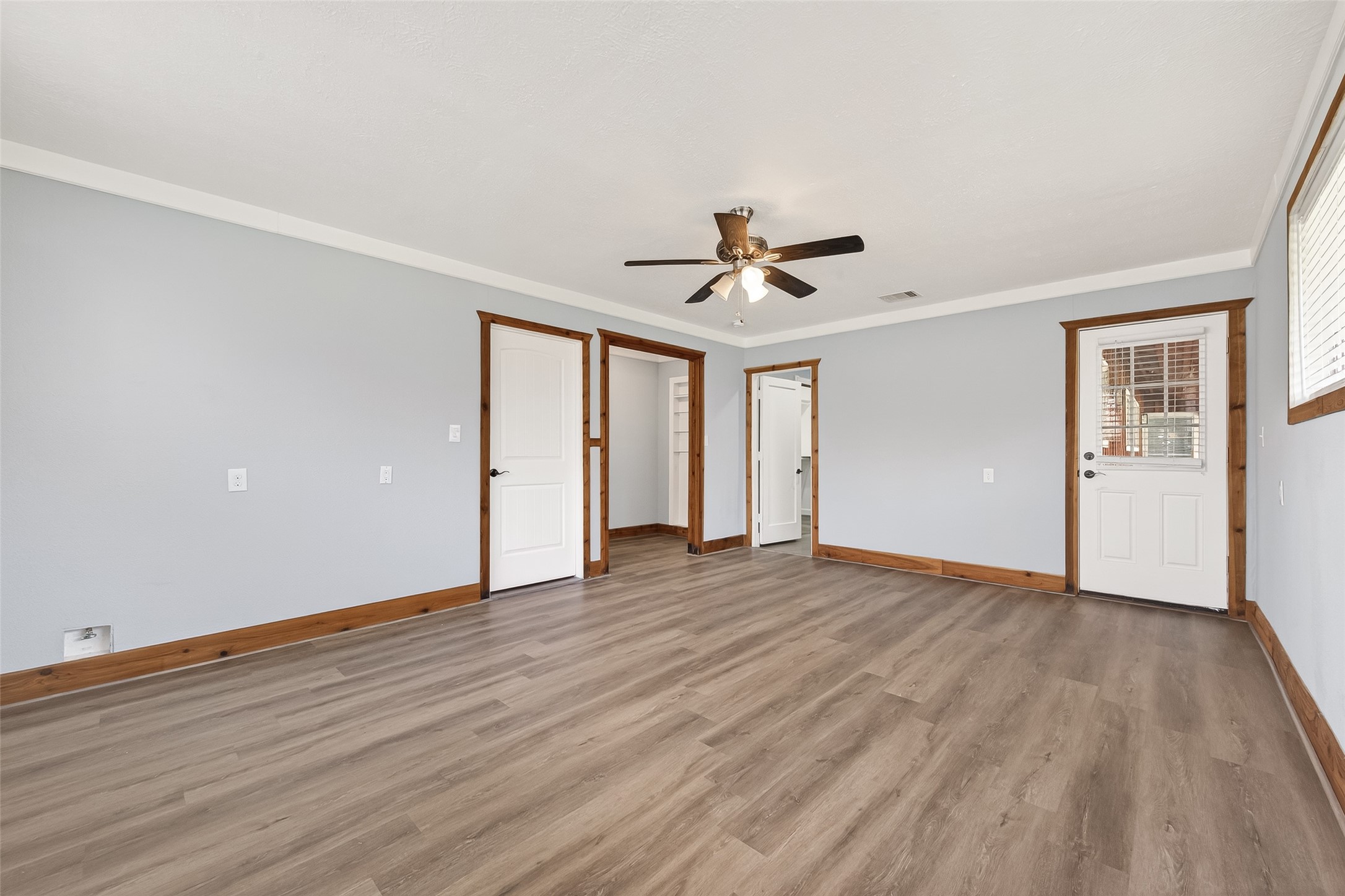 403 Wrangler Road Simonton, TX 77485 - Photo 14 of 33 a view of an empty room with wooden floor and a ceiling fan