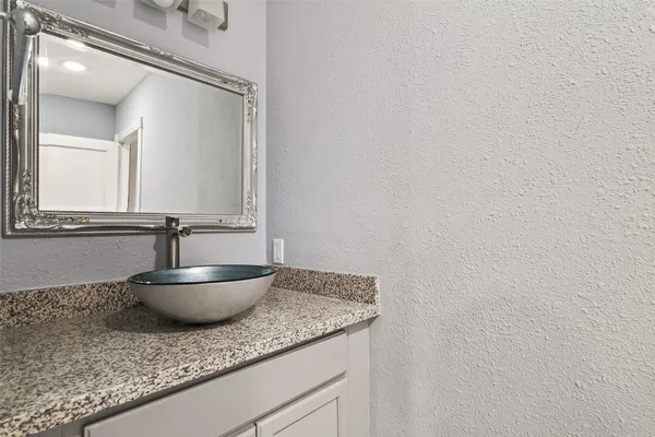 a bathroom with a granite countertop sink and a mirror