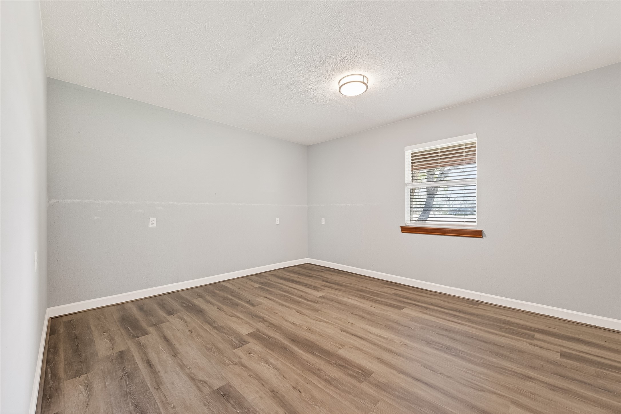 403 Wrangler Road Simonton, TX 77485 - Photo 17 of 33 an empty room with wooden floor and windows